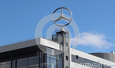 A tall Mercedes-Benz sign with the recognizable brand emblem stands Editorial Stock Photo