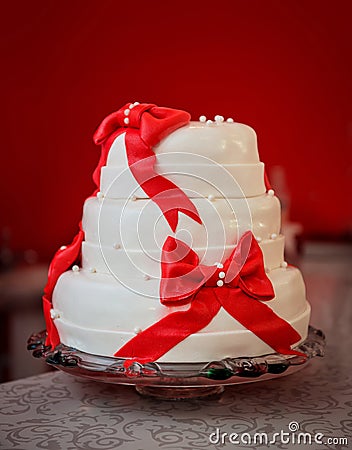 Tall three-tier cake, white with red bows Stock Photo