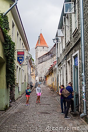 TALLINN, ESTONIA - AUGUST 22, 2016: People walk on a narrow cobbled street in the old town in Tallin Editorial Stock Photo