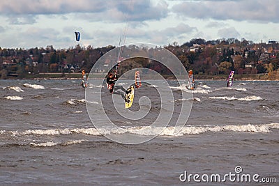 Tallinn, Estonia - October 18, 2008: Kitesurfer jumps high above the sea, doing tricks with bouncing in the windy. Editorial Stock Photo