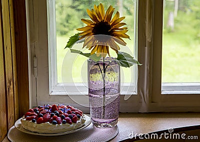 Tallinn, Harjumaa/ Estonia-29AUG2020: Collectible Tarbeklaas vase called Sammal with sunflower and summer cake on window. Editorial Stock Photo