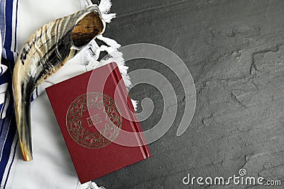 Tallit, shofar and Torah on black slate table, flat lay with space for text. Rosh Hashanah celebration Stock Photo