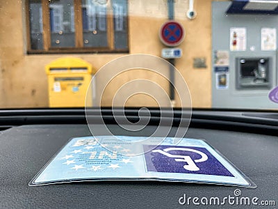 Handicapped card in car at disability parking space Editorial Stock Photo