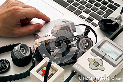 Persons hand coding LEGO MINDSTORMS EV3 robot blocks on laptop Editorial Stock Photo