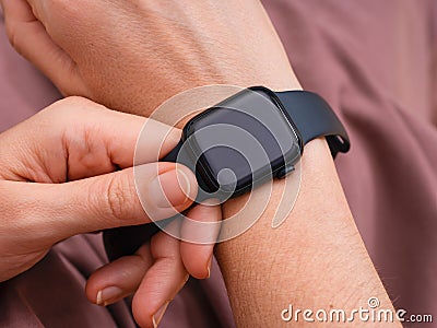 Woman putting an Apple Watch series 7 on to her wrist Editorial Stock Photo