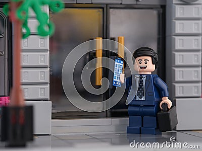 Tambov, Russian Federation - July 26, 2023 A Lego businessman minifigure standing in front of the doors of a bank and answering Editorial Stock Photo