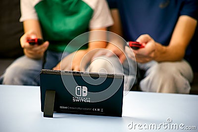 Man and kid playing Nintendo Switch video game console Editorial Stock Photo