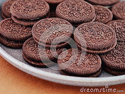 Heap of Oreo cookies on a gray plate. Brown background Editorial Stock Photo