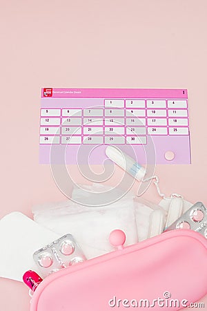 Tampon, feminine, sanitary pads for critical days, feminine calendar, pain pills during menstruation on a pink background. Stock Photo