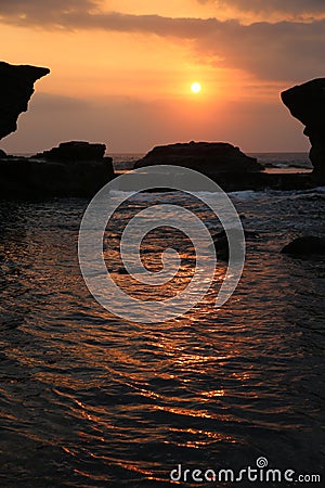 Tanah Lot with water and temple at sunset Stock Photo