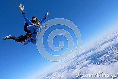 Tandem skydiving. Two guys are in the blue sky. Stock Photo