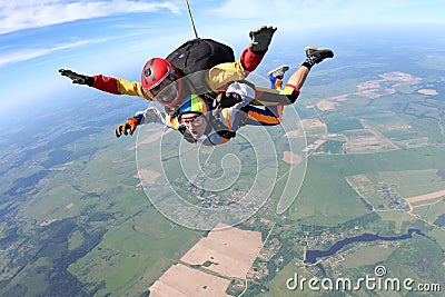Tandem skydiving. Woman and instructor are flying in the sky. Stock Photo
