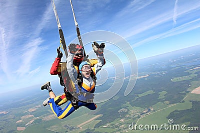 Tandem skydiving. Woman and instructor are in the sky. Stock Photo