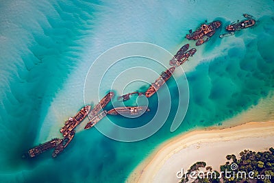 The Tangalooma Wrecks used to be 15 steam driven barges which were deliberately sunk in 1963 along the Moreton Island coastline to Stock Photo