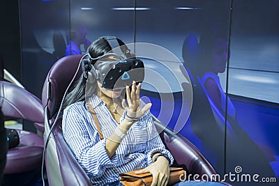 Female visitor trying a driving simulator at GIIAS Editorial Stock Photo