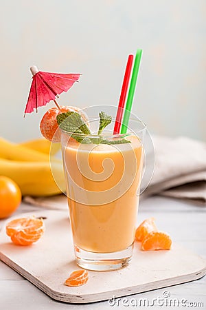 Tangerine and banana smoothie on table Stock Photo