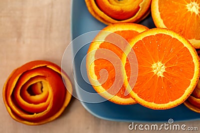 Tangerine on a blue plate with a decor of a peel citrus. Stock Photo