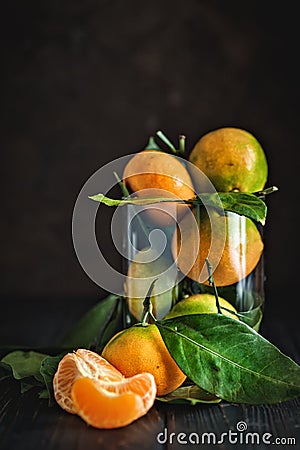 Tangerines with leaves on an old fashioned country table. Selective focus. Vertical. Stock Photo