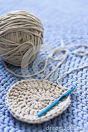 A tangle of gray yarn lies on a blue knitted carpet Stock Photo