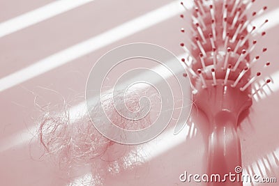 Tangled hair near comb on the table, red tone Stock Photo