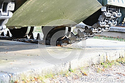 Tank wheels close-up. Iron tracks of a heavy military tank. Iron caterpillars and wheels of a military heavy tank. View of the Stock Photo