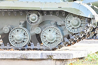 Tank wheels close-up. Iron tracks of a heavy military tank. Iron caterpillars and wheels of a military heavy tank. View of the Stock Photo