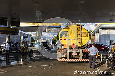 Tanker truck fills the reservoirs with fuel at a gas station belonging to the Ipiranga chain Editorial Stock Photo