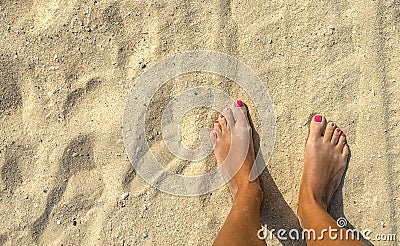Tanned feet on the hot sand Stock Photo
