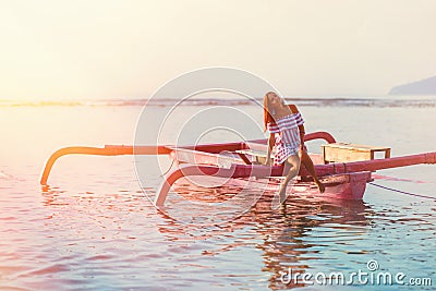 Tanned woman tilted her head while in the boat at sunset. in soft focus Stock Photo