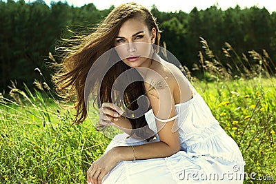 Tanned woman in white summer dress Stock Photo
