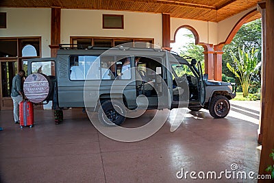 Land Cruiser safari vehicle being loaded with passengers luggage prior to leaving the lodge to Editorial Stock Photo