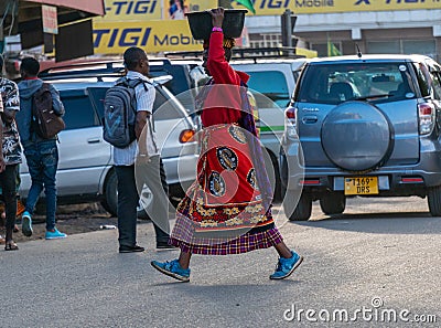 TANZANIA, ARUSHA - 15 Jan 2020: Carry good on the head is african skill. People on the street in Arusha city, Tanzania Editorial Stock Photo