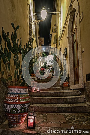 Taormina Sicily, old streets of Taormina during evening with the lights on and people on the terrace Editorial Stock Photo