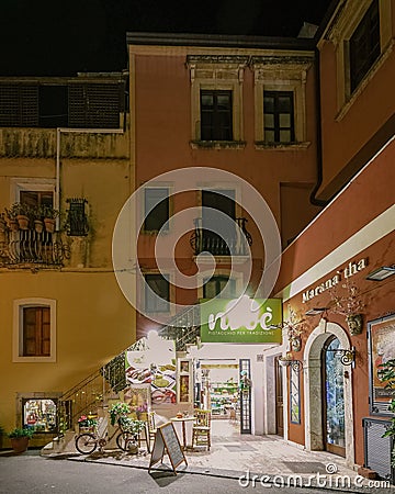 Taormina Sicily, old streets of Taormina during evening with the lights on and people on the terrace Editorial Stock Photo