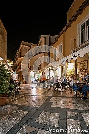 Taormina Sicily, old streets of Taormina during evening with the lights on and people on the terrace Editorial Stock Photo