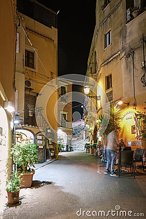 Taormina Sicily, old streets of Taormina during evening with the lights on and people on the terrace Editorial Stock Photo