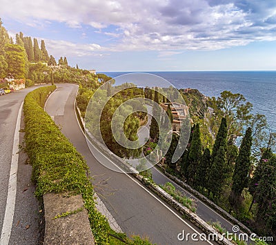 Taormina, Sicily - The streets of the famous hilltop town of Taormina with palm tree, mediterranean sea Stock Photo