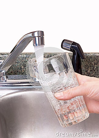 Tap water filling glass Stock Photo