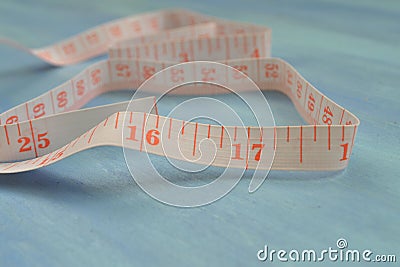 Tape measure half-rolled out. Measuring cm and inches. Tailoring tools. Pocket measure Stock Photo