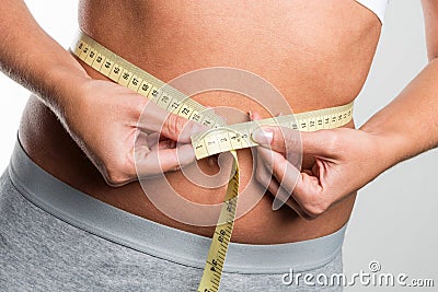 Tapeline measures belly of young woman Stock Photo