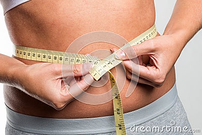 Tapeline measures young woman's waist Stock Photo