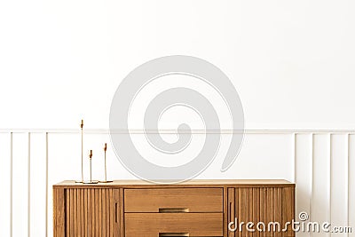 Taper candle holders on a wooden sideboard table Stock Photo