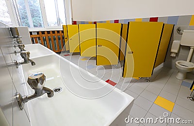 Taps of washbasin and yellow doors in the bathroom of a nursery Stock Photo