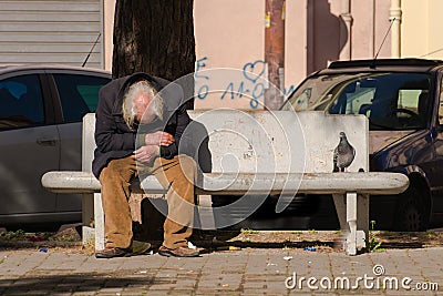 Taranto, Apulia / Italy - 03/23/2019 : A lost homeless old man depressed on bench Editorial Stock Photo