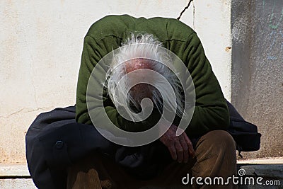 Taranto, Apulia / Italy - 03/23/2019 : A lost homeless old man depressed on bench Editorial Stock Photo