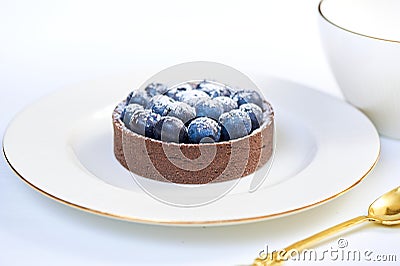 Tarlets dessert from pistachio and chocolaty bakery dough with blueberry decoration Stock Photo