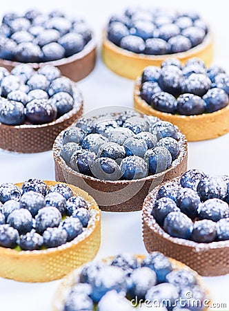 Tarlets dessert from pistachio and chocolaty bakery dough with blueberry decoration Stock Photo