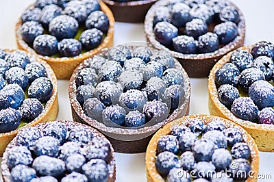 Tarlets dessert from pistachio and chocolaty bakery dough with blueberry decoration Stock Photo