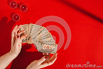 Tarot cards and female hands of fortune teller on red background Stock Photo