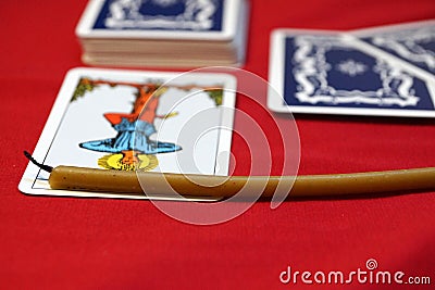 Tarot cards and wax extinguished candle on red material, Tarot card The Hanged Man Stock Photo